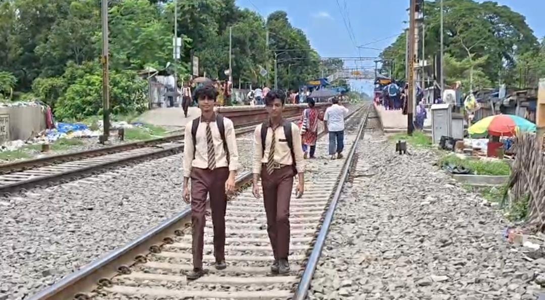 রাস্তা জলে ডুবে, ভরসা রেললাইন! মল্লিকপুরে প্রাণের ঝুঁকি নিয়ে স্কুলে যাতায়াত পড়ুয়াদের